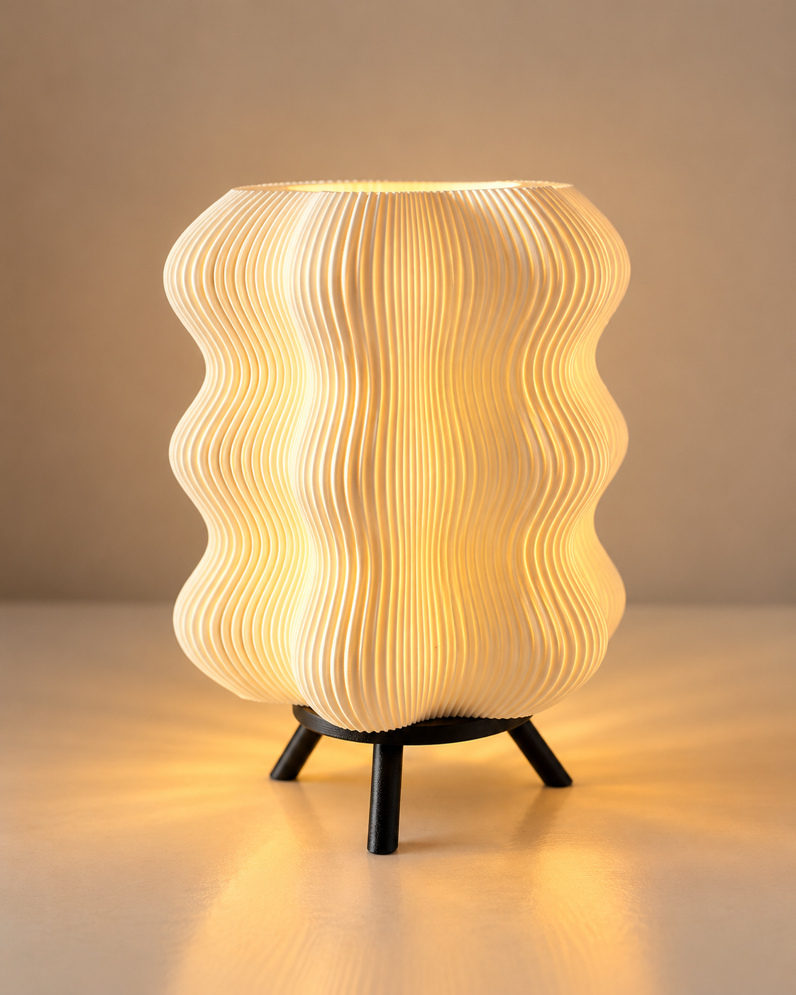 Glowing table lamp with a wavy ribbed shade and black tripod base.